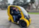 zwei Personen sitzen in einem gelben Fahrzeug