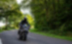 Motorcyclist on machine drives on country road