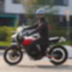 Mann fährt auf Motorrad mit rotem Tank