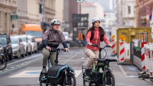 Zwei Fahrradfahrer im Straßenverkehr mit Lastenrädern