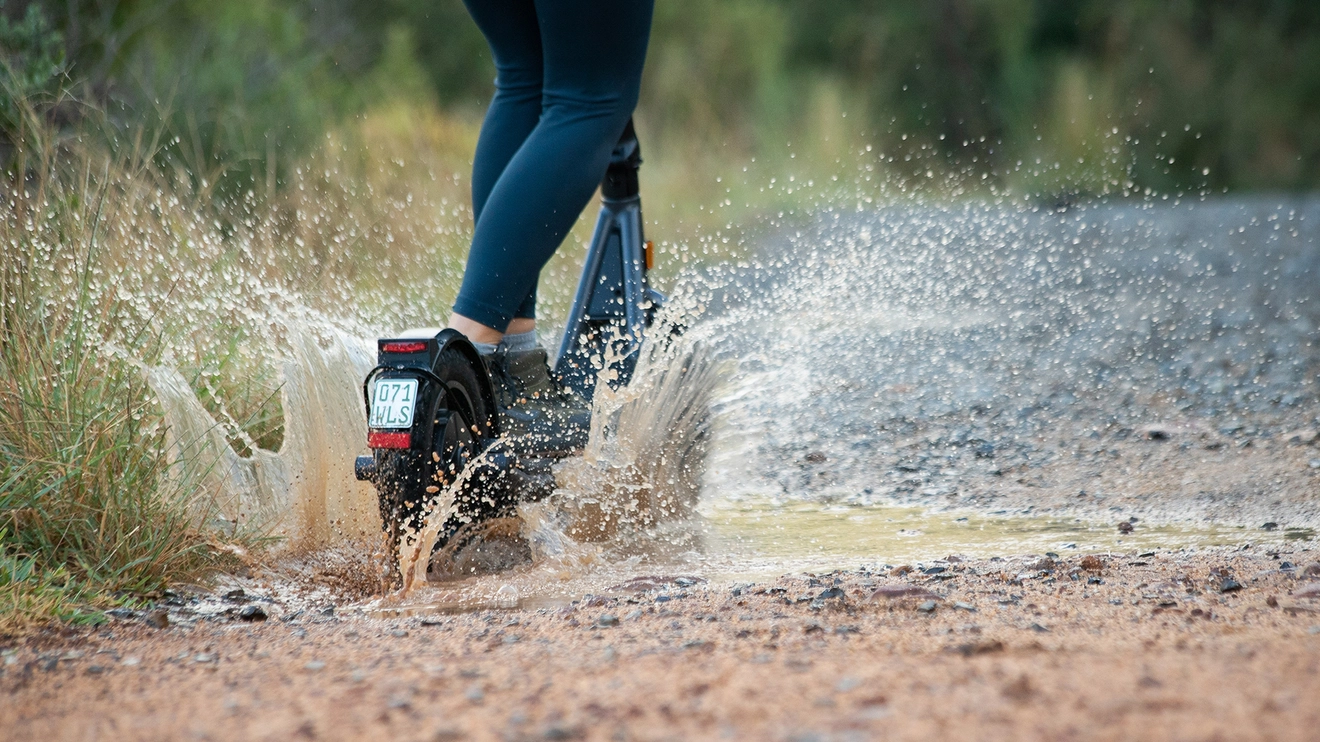 e-Scooter fährt durch Pfütze