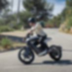 Mann fährt auf futuristischen Motorrad auf Landstraße