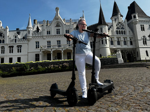 Frau mit e-Scootern vor Schloß