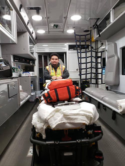 Jordan on the back of an ambulance getting ready for calls