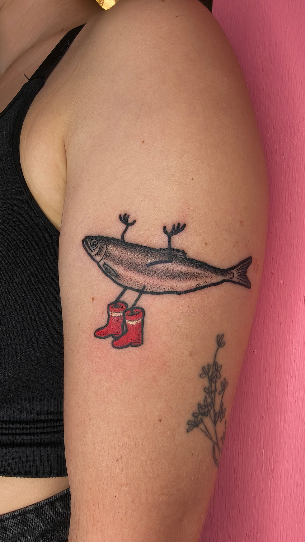 Whale tattoo wearing red boots on an upper arm