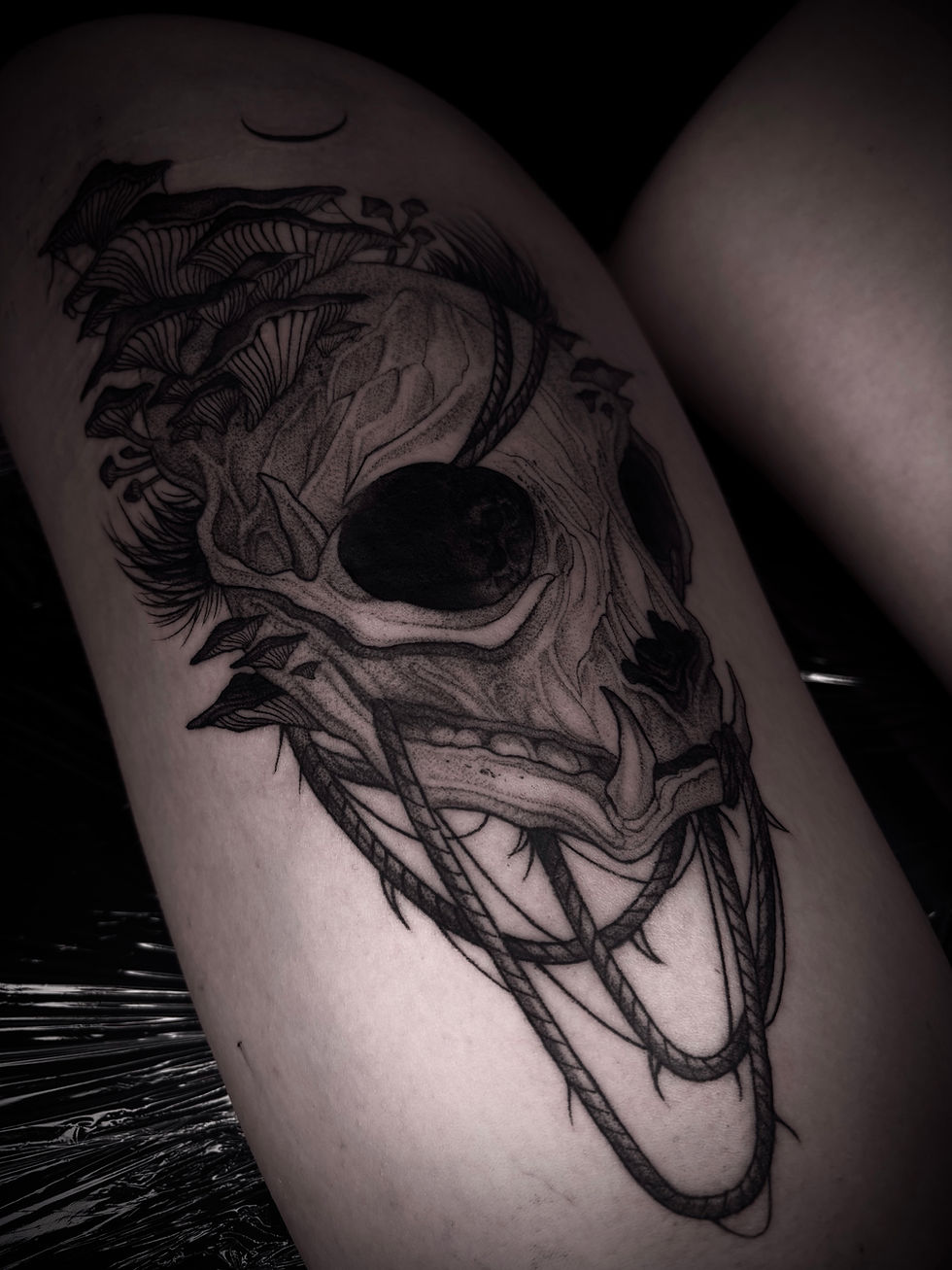 Black and grey skull tattoo with thorny vines