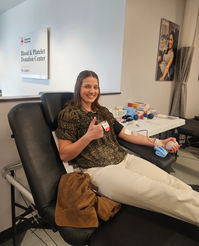 D.L. Evans Bank employee donating blood and giving a thumbs up at an American Red Cross blood drive.