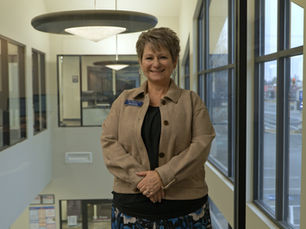 Dana Stewart standing smiling in front of a window at the D.L. Evans Bank Twin Falls Financial Center.