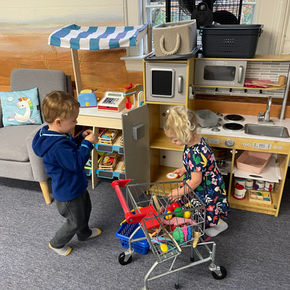 two toddlers playing with kitchen and store playlet