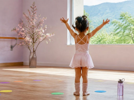 窓辺で両手を上げる小さな女の子の後ろ姿のイメージ