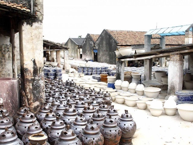A local artisan shaping clay on a pottery wheel in Bat Trang Ceramic Village