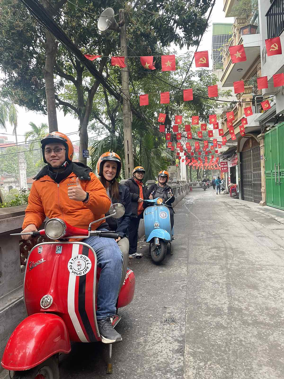 Vespa parked in narrow 1.2-meter Hanoi alley accessing authentic street food vendor