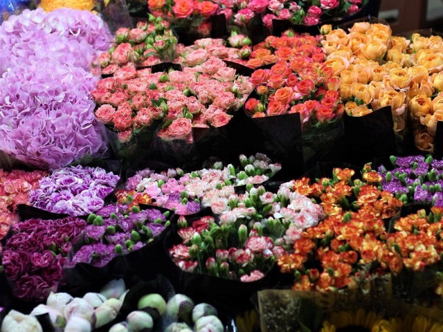 Colorful flower stalls and vendors at dawn in Quang Ba Flower Market