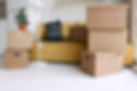 Moving boxes in a room with a yellow couch
