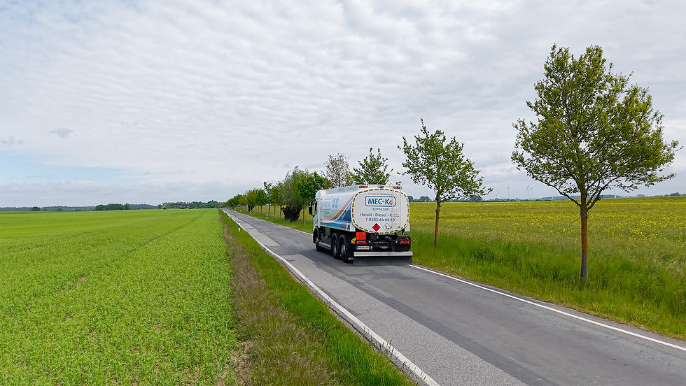 Ein LKW fährt auf einer Straße zwischen Feldern