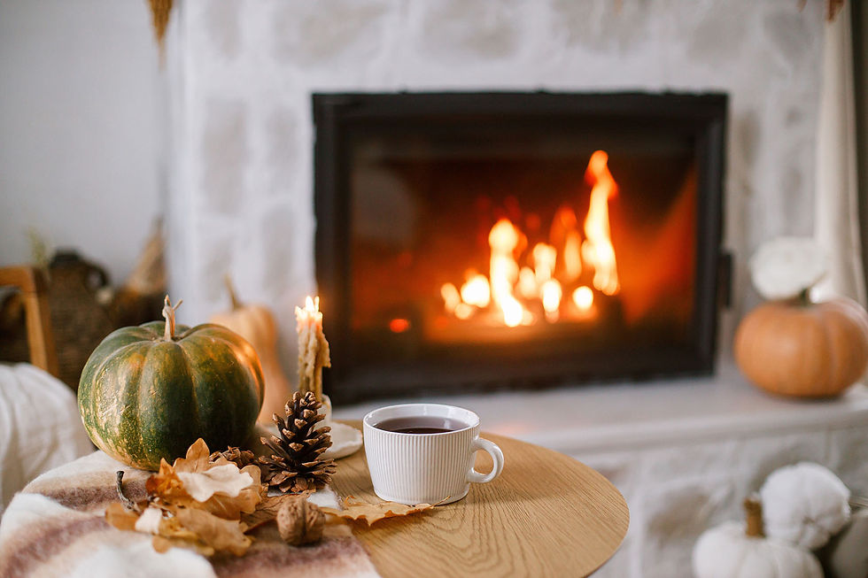 Ein Tisch mit einer Tasse und Holzdeko steht vor einem Kamin mit Feuer