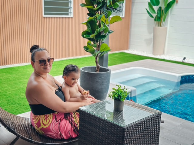 Mother and son beside a private pool, looking towards their villa at Le Ama Luxury Villas in Samoa.