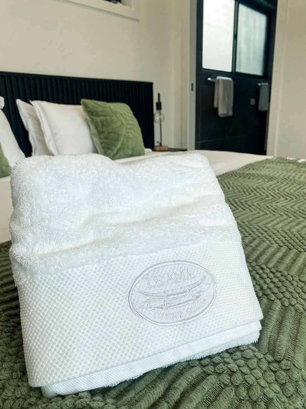 Folded embossed towel on a bed inside a Le Ama Luxury Villas villa in Samoa.