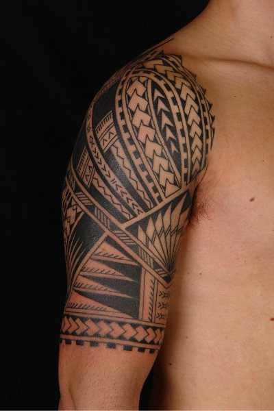 Polynesian half sleeve tattoo on arm of man