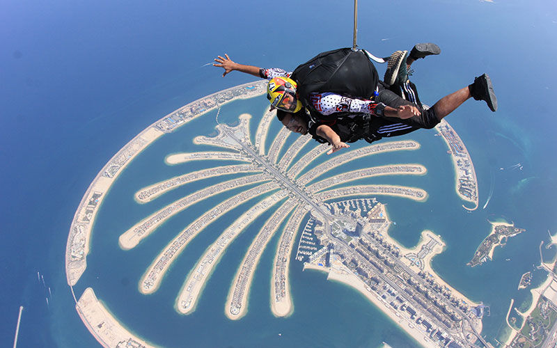 Man doing skydiving above palm jumeirah in dubai