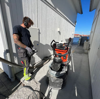 Person som slipar betongplatta utomhus.