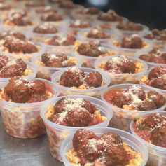 Multiple plastic containers filled with mini meatballs and pasta.
