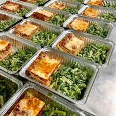 Prepared plates of lasagna bolognese and green beans