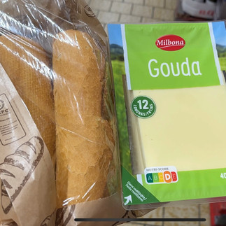 Wij genieten lekker van een broodje met kaas tijdens een picknick op het strand