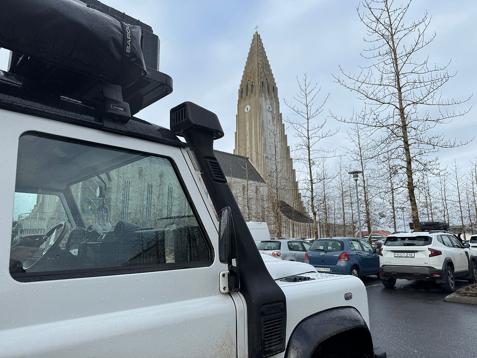 Onze Defender met Hallgrímskirkja op de achtergrond in Reykjavik