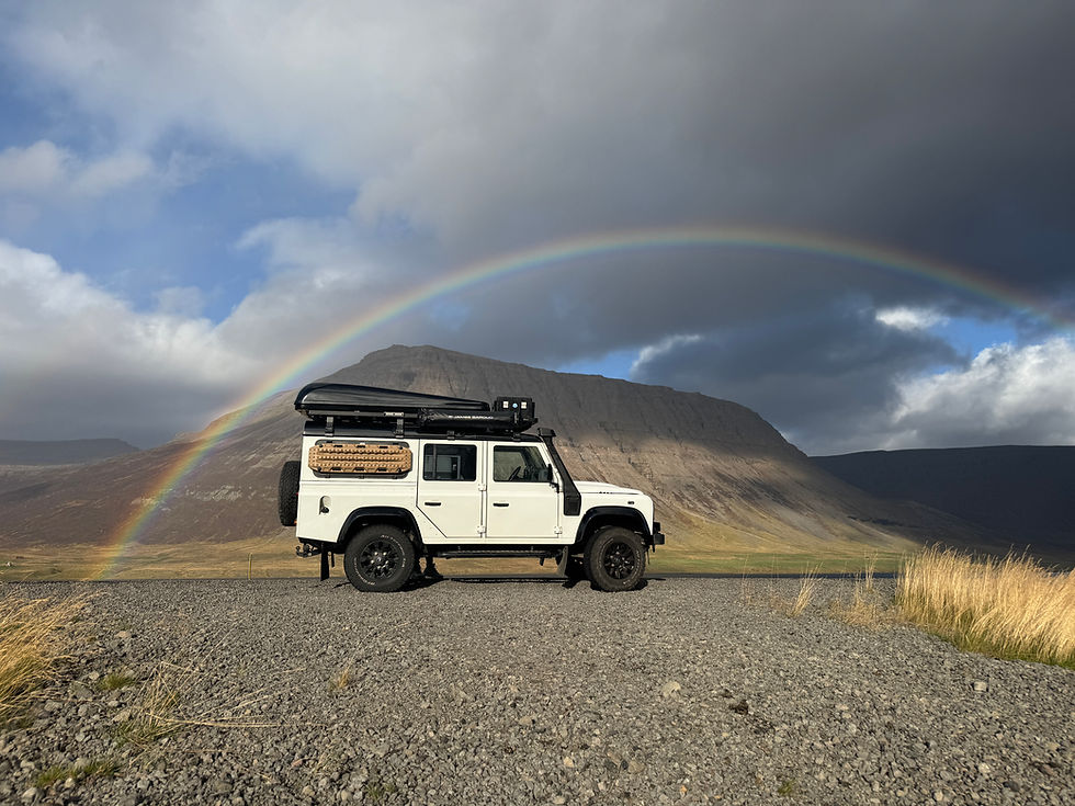 Onze Land Rover Defender in de prachtige natuur met regenboog in IJsland