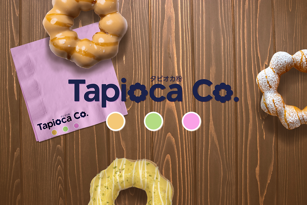 Dark blue Tapioca Co logo on a brown wood background with mochi donuts and a pink napkin with logo branding