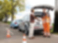 Roadside assistance technician shaking hands with a happy customer after a successful car jump start