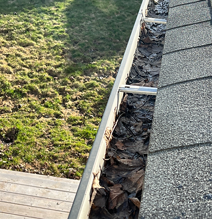 Clogged commercial gutter filled with debris before gutter guard installation.