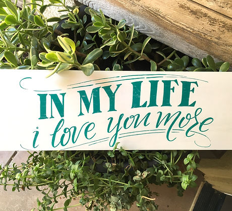 Hand drawn sign in greenery.