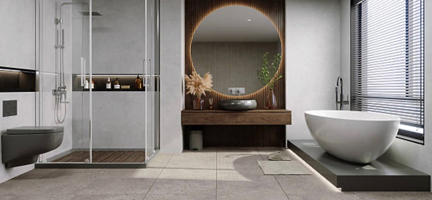 Grey bathroom with glass shower, round mirror and freestanding bath