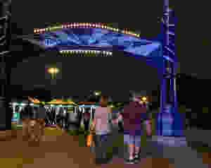 Man and teen daughter walking under sign that says Downtown Disney