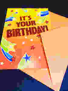 It is a yellow birthday card that says It's Your Birthday