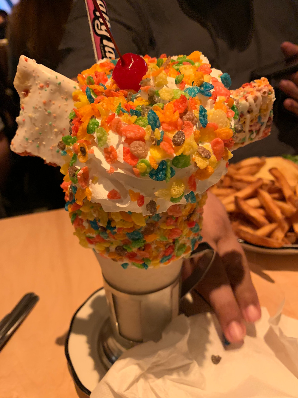 A Fruity Pebbles shake with a Pop Tart, Rice Krispy treat, Laffy Taffy candy, Whipped cream and cherry