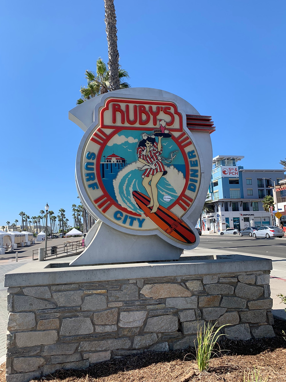The sign says Ruby's Diner Surf City and has a woman on a surf board