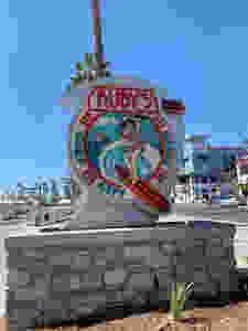 The sign says Ruby's Diner Surf City and has a woman on a surf board