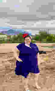 woman wearing a blue dress with mountains in the background