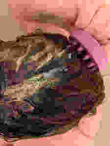 woman using a shampoo brush to wash hair