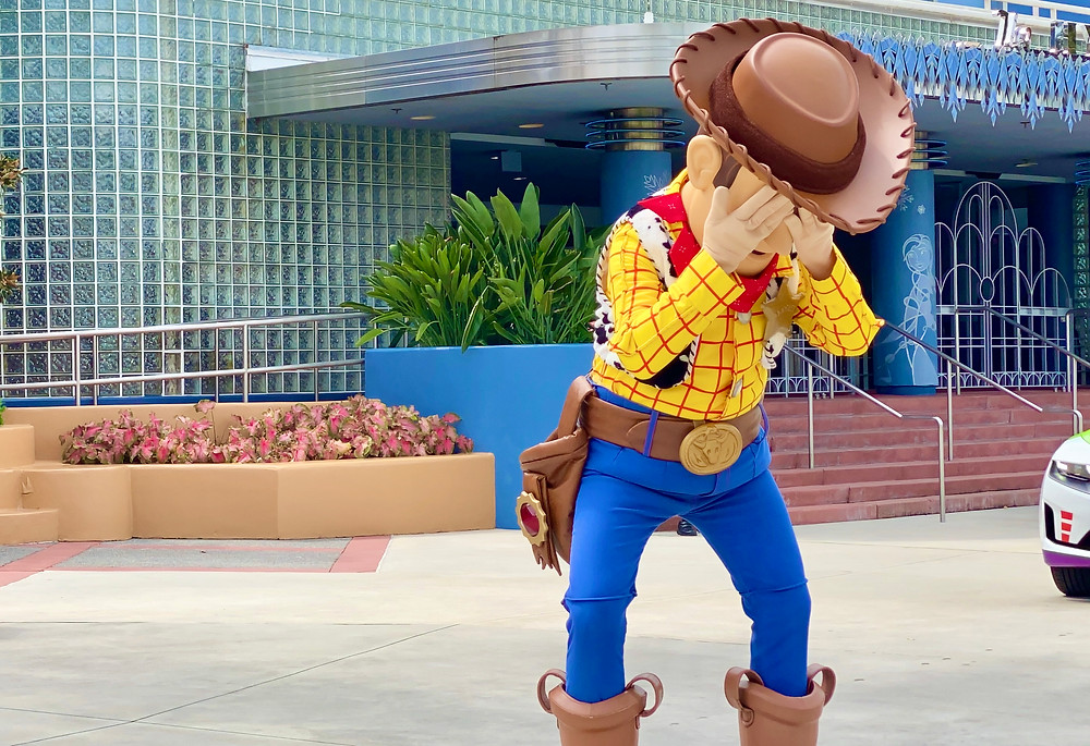 the character Woody from Toy Story, a cowboy, covering his eyes.