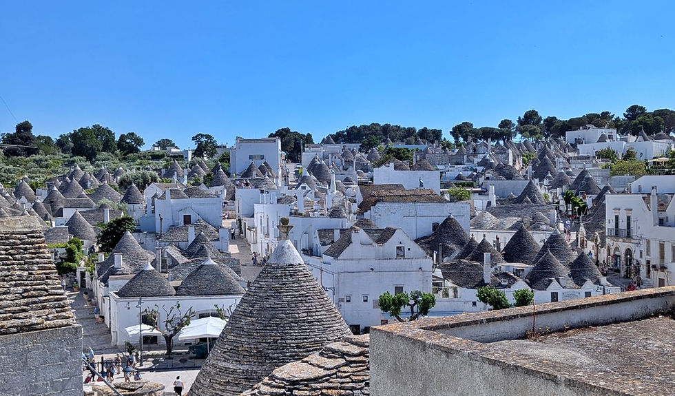 Ruelles de trulli blancs en pierre sous un ciel bleu, Alberobello