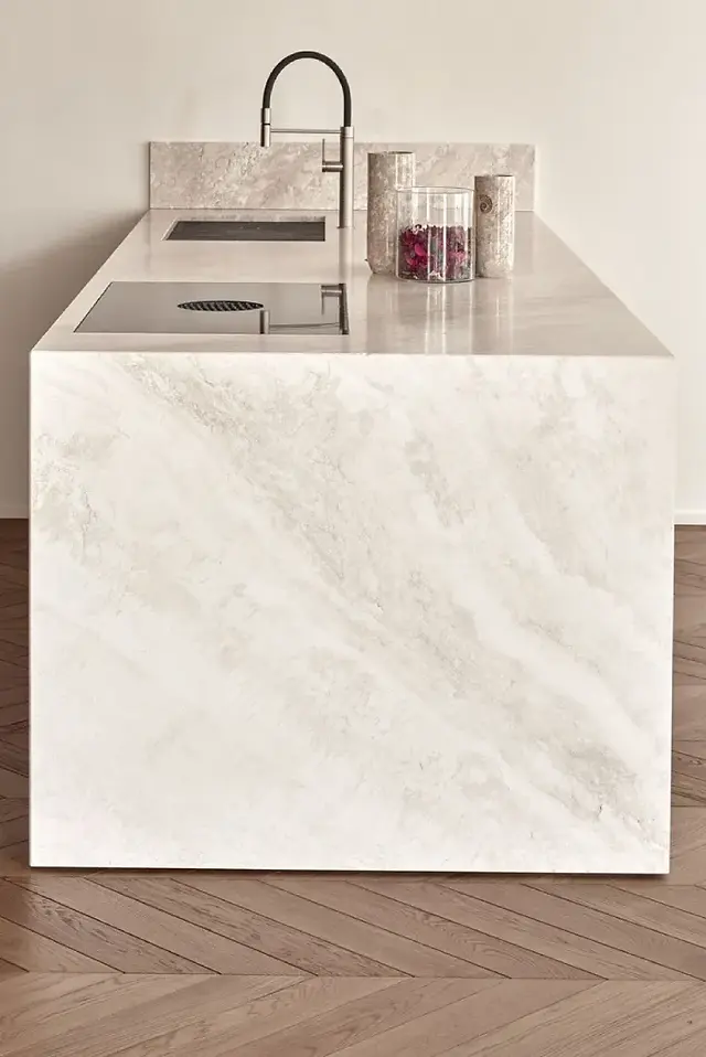 Close-up of waterfall kitchen island featuring premium natural stone countertop in luxury kitchen.