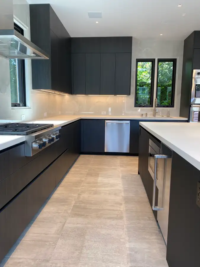 Luxury European kitchen featuring continuous tile flooring installed before cabinetry for a clean architectural finish.