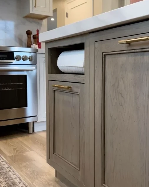 Built-in paper towel holder concealed within custom kitchen cabinetry