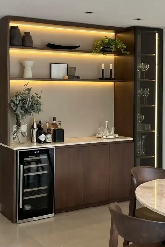 Undercounter beverage refrigerator integrated into a custom home bar and cabinetry