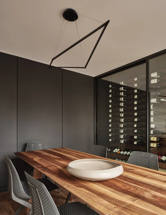 Custom wine storage behind glass in a modern San Francisco Bay Area dining room with walnut table and minimalist design.