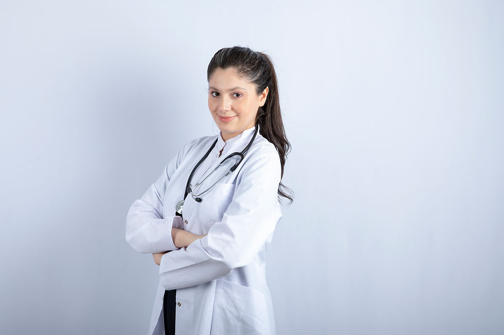 hermosa-doctora-en-bata-blanca-con-los-brazos-cruzados-sobre-la-pared-blanca.jpg